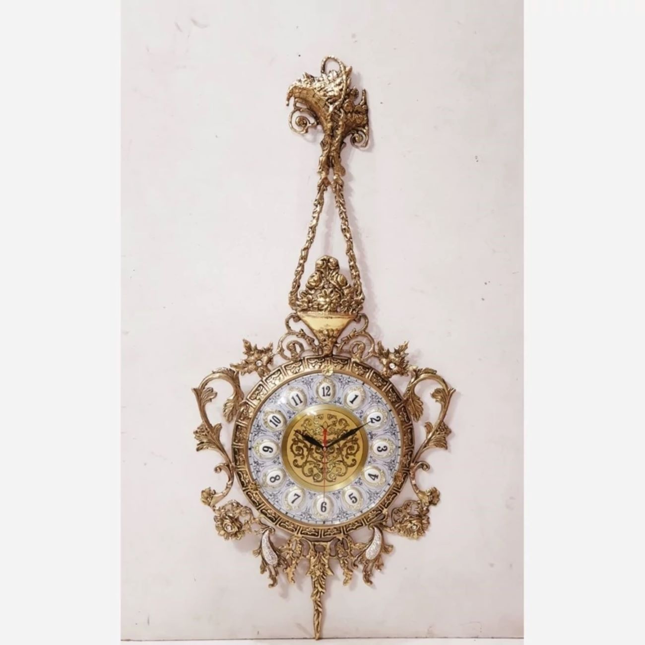 Charming Brass Wall Clock with Decorative Floral Accents and Hanging Detail